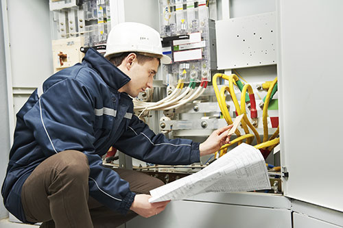 Technician working on electronic in a machine cabinet