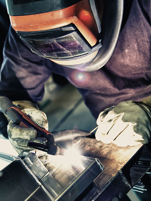 Technician welding on a piece of equipment