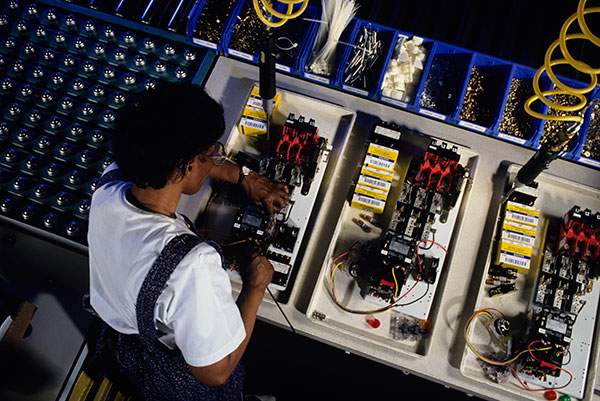 A techniciam working on a circuit board