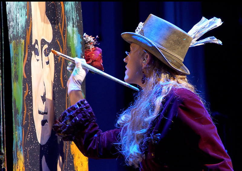 Artist painting a picture during Artrageous show